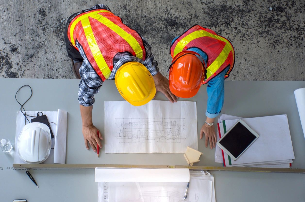 two constructors in miami looking maps on a table